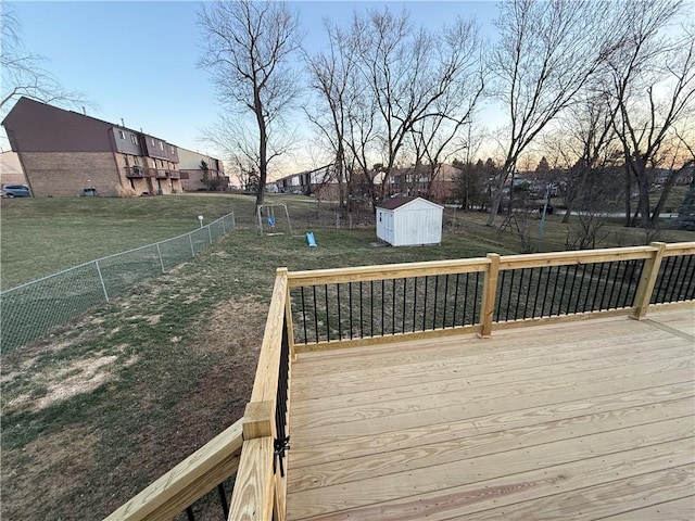 deck with a yard, a storage shed, an outdoor structure, and fence