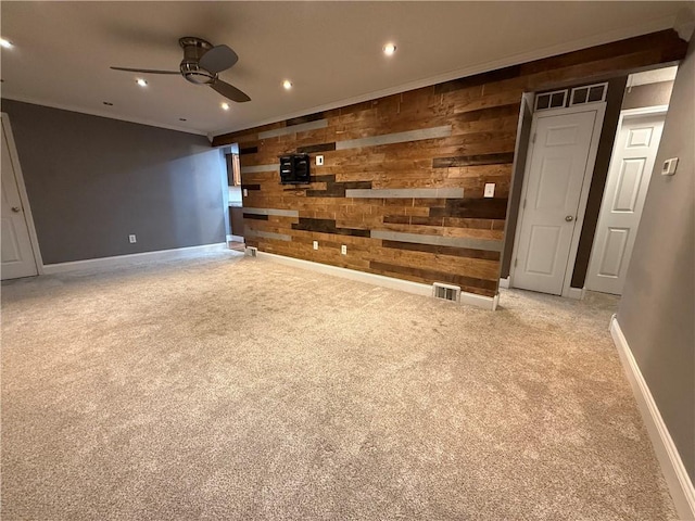 unfurnished living room with recessed lighting, visible vents, carpet floors, and wooden walls