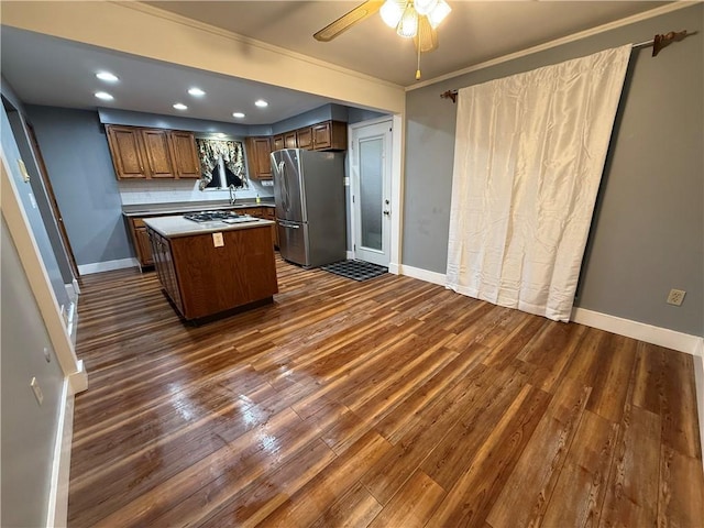 kitchen with dark wood finished floors, a center island, freestanding refrigerator, recessed lighting, and baseboards