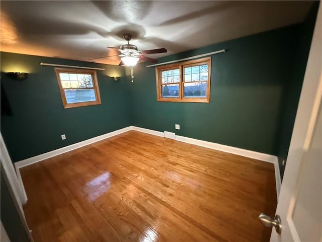 unfurnished bedroom with wood finished floors, baseboards, and ceiling fan