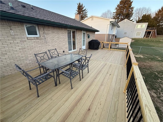 wooden deck featuring outdoor dining area, grilling area, and fence