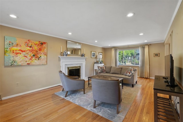 living area with light wood finished floors, baseboards, and ornamental molding