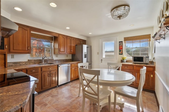 kitchen featuring a sink, brown cabinets, baseboard heating, and stainless steel appliances