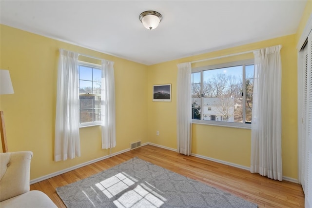 interior space with wood finished floors, visible vents, and baseboards