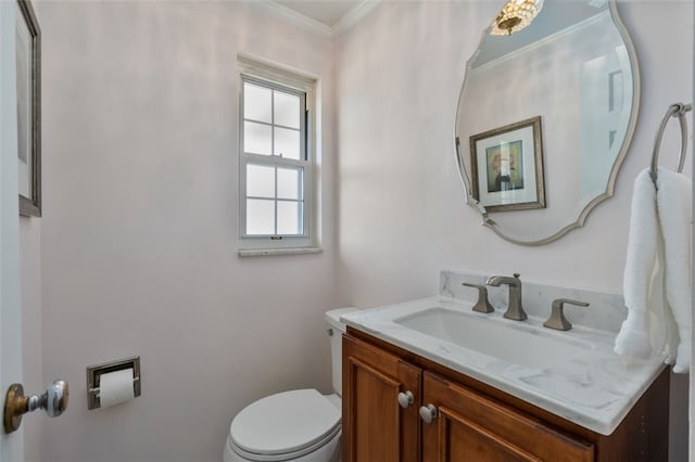 half bathroom with toilet, vanity, and ornamental molding