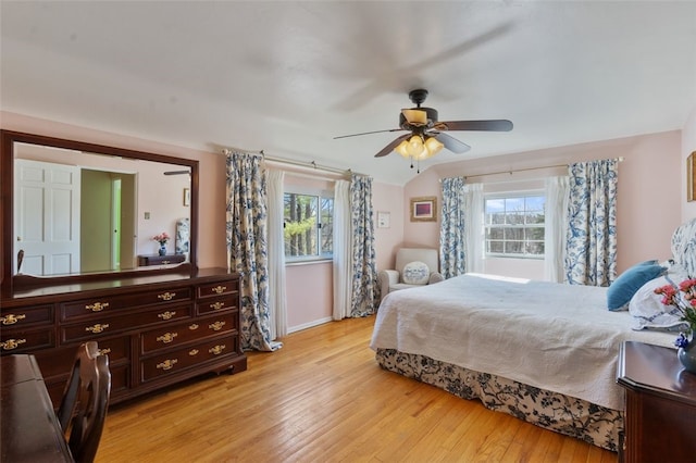 bedroom featuring light wood finished floors, baseboards, and ceiling fan