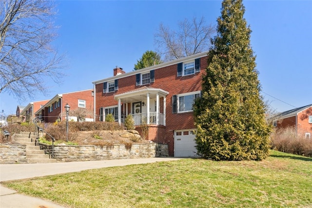 view of front of property featuring a front yard, an attached garage, a chimney, concrete driveway, and brick siding