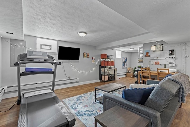 living area featuring a baseboard heating unit, a textured ceiling, wood finished floors, baseboards, and baseboard heating