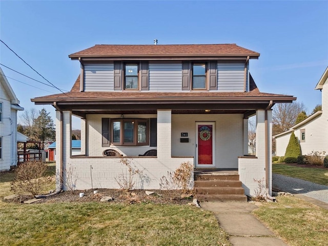 view of front of home featuring a front lawn, brick siding, and covered porch