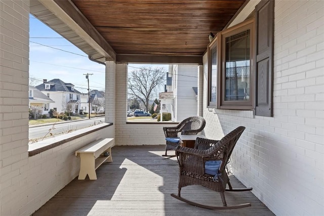 wooden deck featuring a residential view and a porch