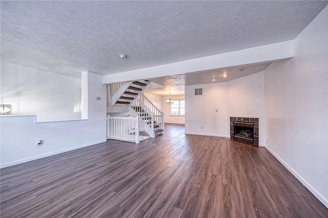 unfurnished living room featuring stairway, a fireplace, dark wood-type flooring, and baseboards