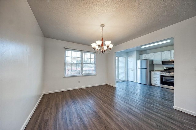 unfurnished dining area with an inviting chandelier, a textured ceiling, baseboards, and dark wood-style flooring