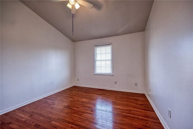 spare room featuring a ceiling fan, lofted ceiling, baseboards, and dark wood-style flooring