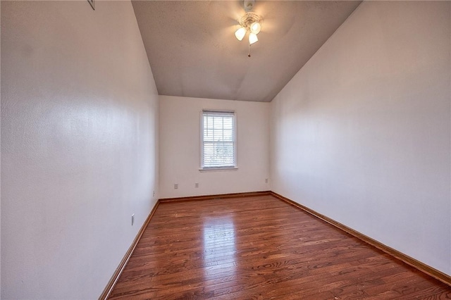 spare room featuring ceiling fan, baseboards, lofted ceiling, and wood finished floors