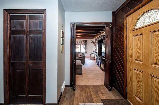 entrance foyer featuring baseboards, dark wood-type flooring, and a textured ceiling