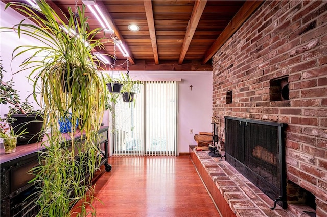 exterior space with beamed ceiling, a brick fireplace, wooden ceiling, and wood finished floors