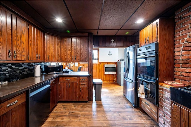 kitchen featuring dark countertops, decorative backsplash, appliances with stainless steel finishes, wood finished floors, and heating unit