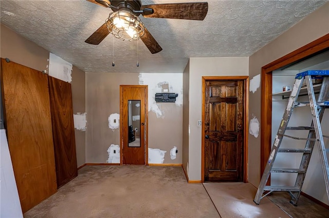 interior space with baseboards, carpet floors, and a textured ceiling