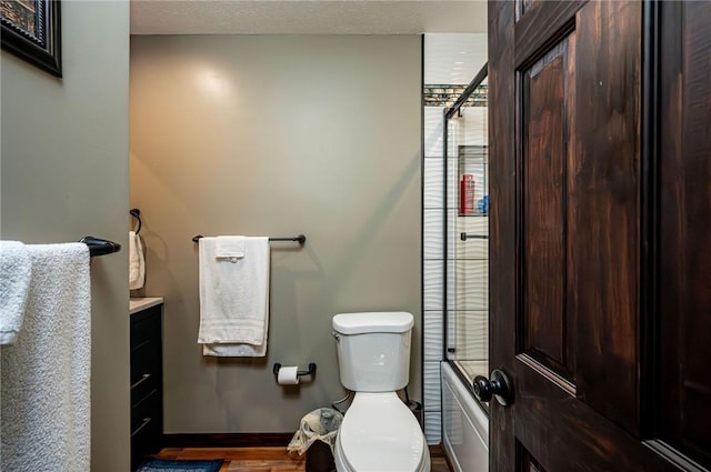 full bathroom featuring toilet, wood finished floors, a shower, baseboards, and vanity