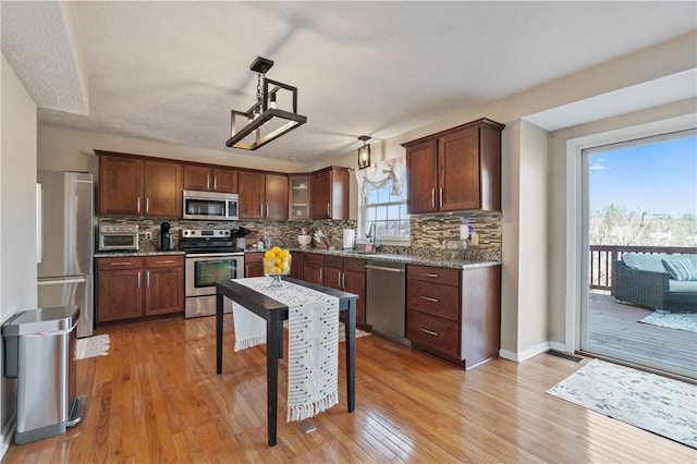 kitchen with light wood-style floors, appliances with stainless steel finishes, and a sink