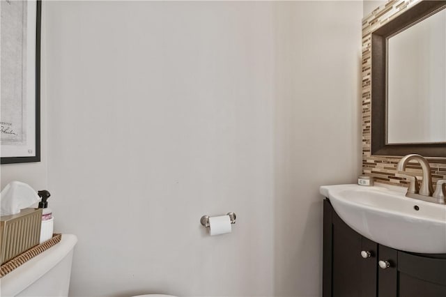 bathroom featuring backsplash, toilet, and vanity