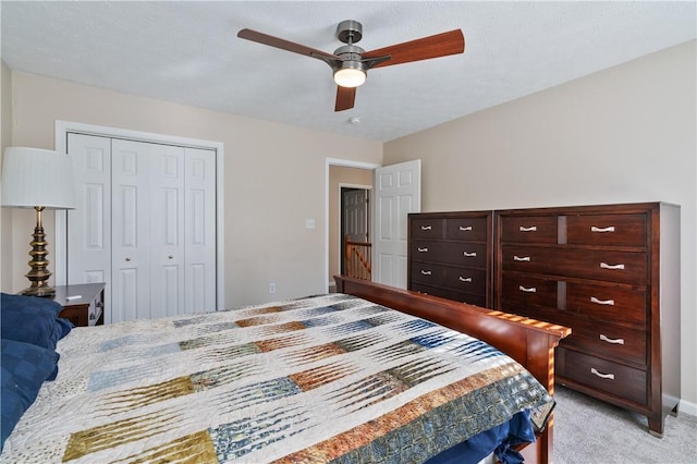 bedroom with baseboards, light colored carpet, a closet, and ceiling fan