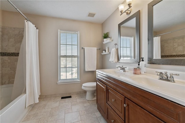 full bath with a sink, visible vents, toilet, and shower / bath combination with curtain