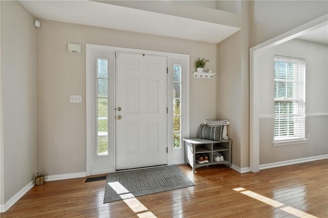 foyer featuring baseboards and hardwood / wood-style flooring