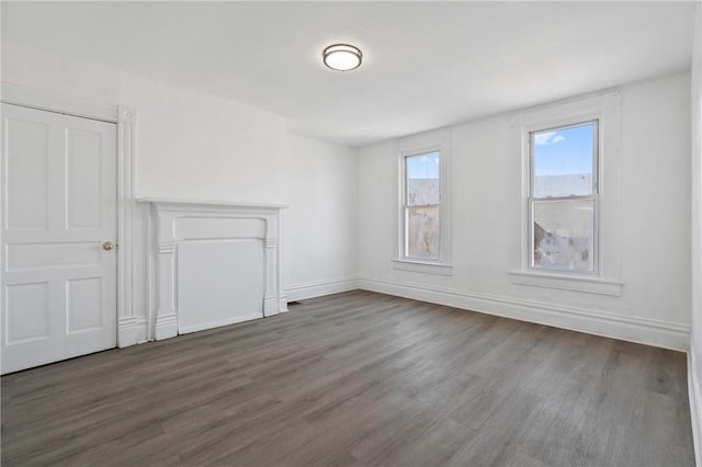 unfurnished living room featuring wood finished floors and baseboards