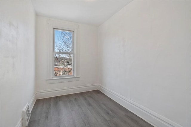 empty room with visible vents, baseboards, and wood finished floors