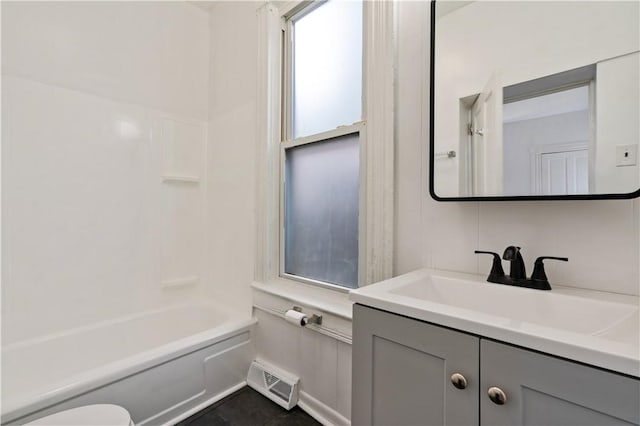 bathroom with visible vents, toilet, vanity, and bathing tub / shower combination