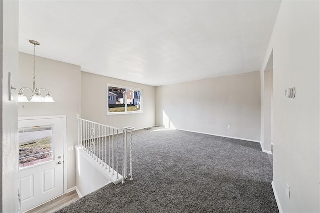 interior space featuring carpet flooring, baseboards, and an inviting chandelier