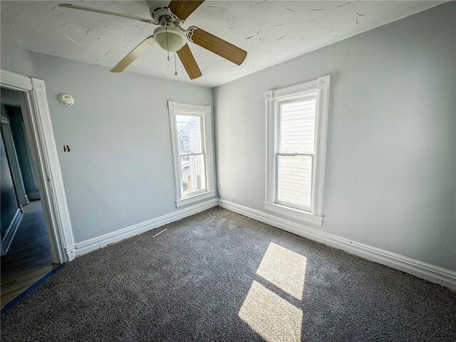 spare room featuring baseboards, carpet floors, and a ceiling fan