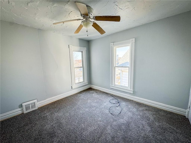 empty room featuring visible vents, carpet flooring, plenty of natural light, and baseboards