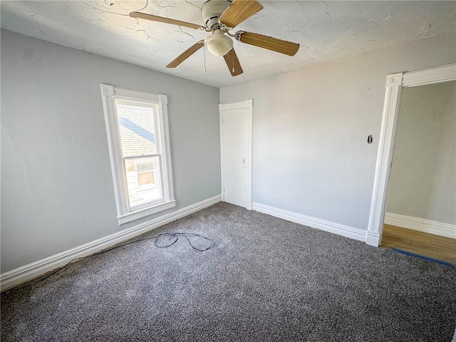 spare room with carpet flooring, a textured ceiling, baseboards, and a ceiling fan