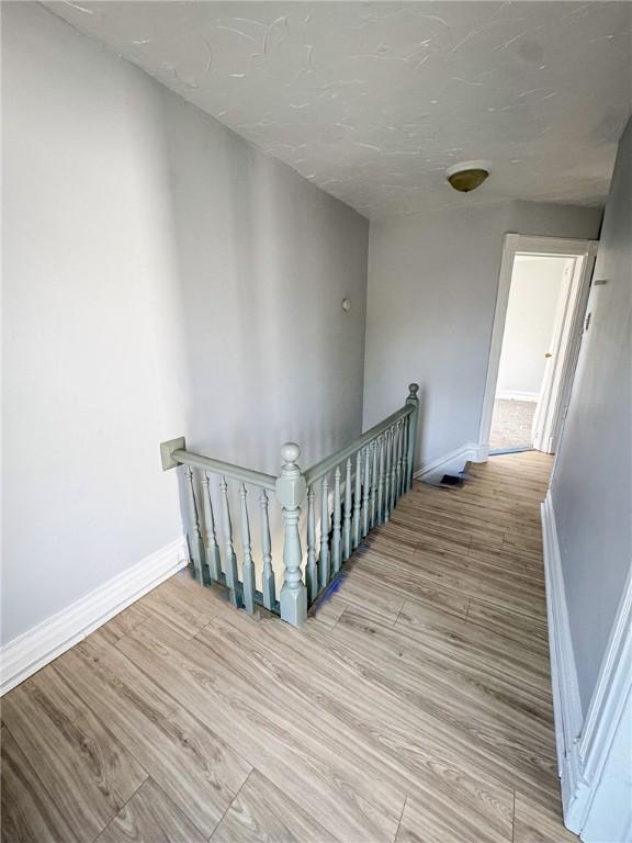 stairway with baseboards and wood finished floors