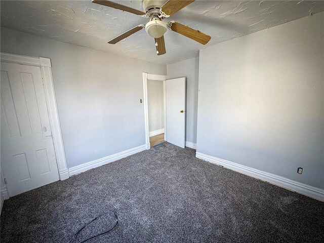 unfurnished room featuring a ceiling fan, carpet, and baseboards