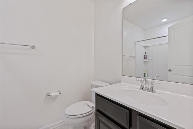 bathroom with baseboards, toilet, and vanity