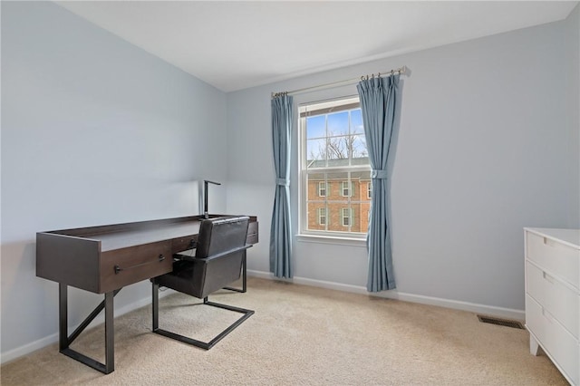 office area featuring light colored carpet, visible vents, and baseboards