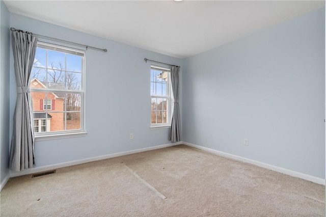 unfurnished room with plenty of natural light, carpet, and visible vents