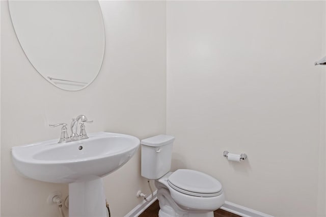 bathroom with toilet and baseboards