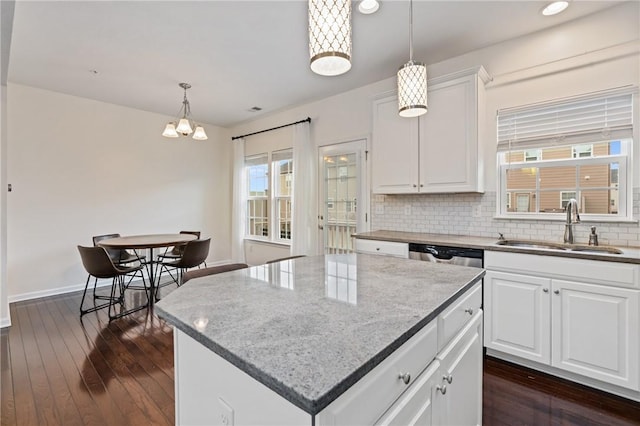 kitchen with a sink, dark wood-type flooring, white cabinets, dishwasher, and tasteful backsplash