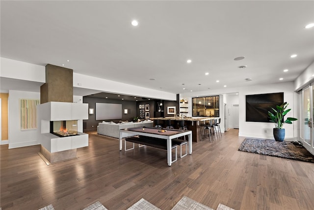 living room with recessed lighting, indoor bar, and wood finished floors