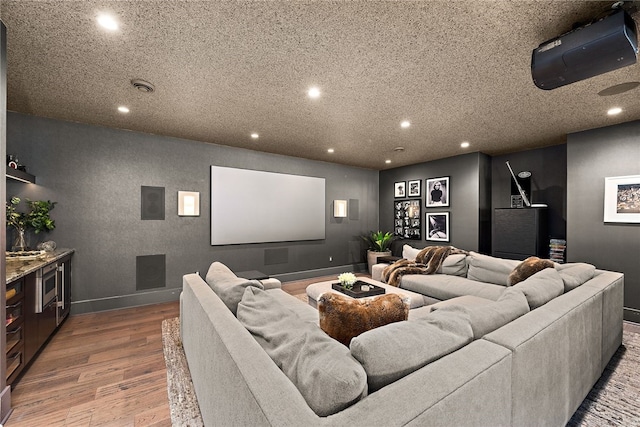 home theater room with visible vents, recessed lighting, wood finished floors, and baseboards