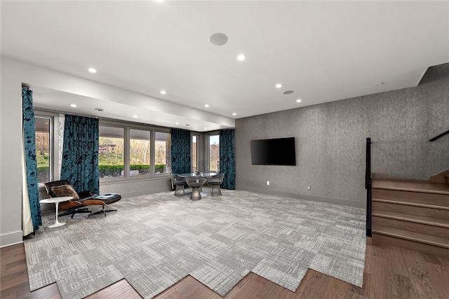 sitting room with wood finished floors, recessed lighting, wallpapered walls, baseboards, and stairs