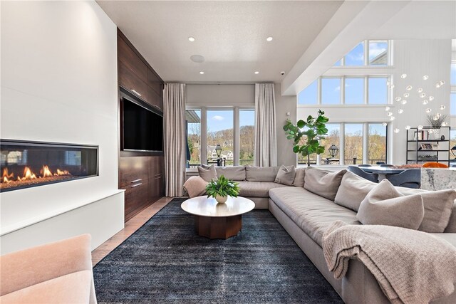 living area featuring light wood finished floors, a glass covered fireplace, and recessed lighting