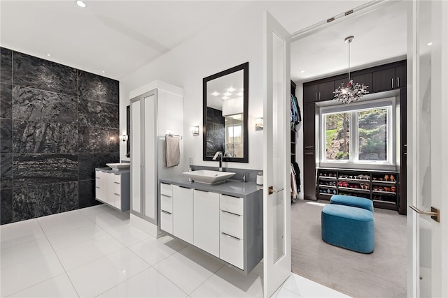 full bath with two vanities, recessed lighting, tile patterned floors, tile walls, and a sink