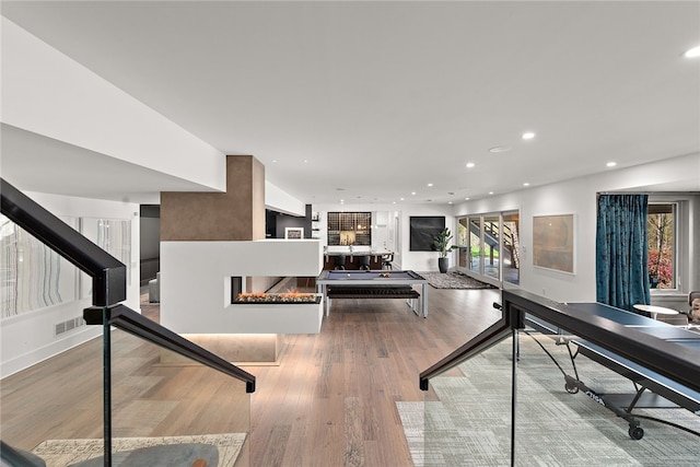 recreation room featuring visible vents, recessed lighting, a fireplace, and wood finished floors