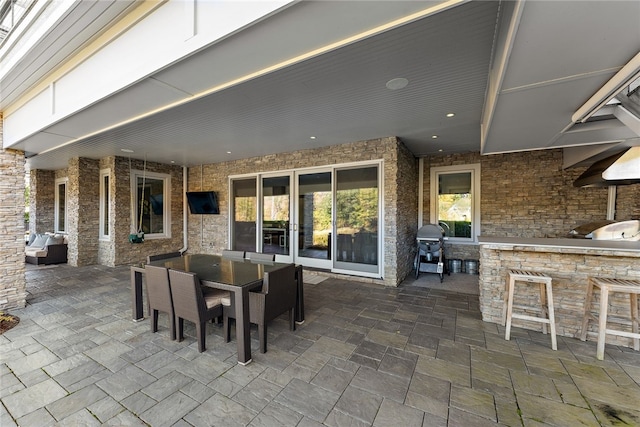 view of patio featuring exterior kitchen, outdoor dining area, outdoor dry bar, and grilling area