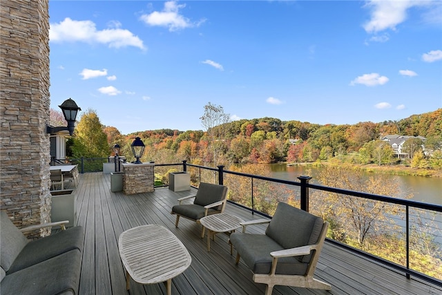 wooden terrace with a wooded view and a water view